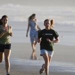 Two young women jogging on the beach