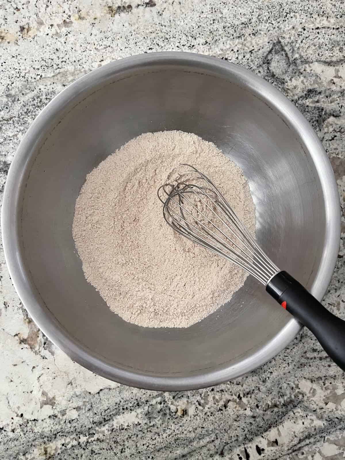 Whisking whole wheat pastry flour, salt, baking soda and cinnamon in mixing bowl.