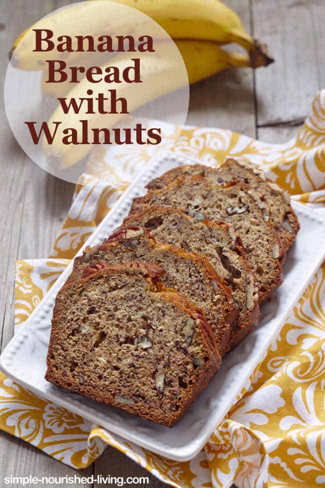 Slices of Moist Banana Bread with Walnuts on white serving plate with yellow and white napkins.