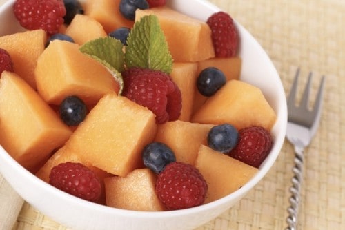 Fresh Fruit Salad with cantaloupe, raspberries and blueberries in a white bowl