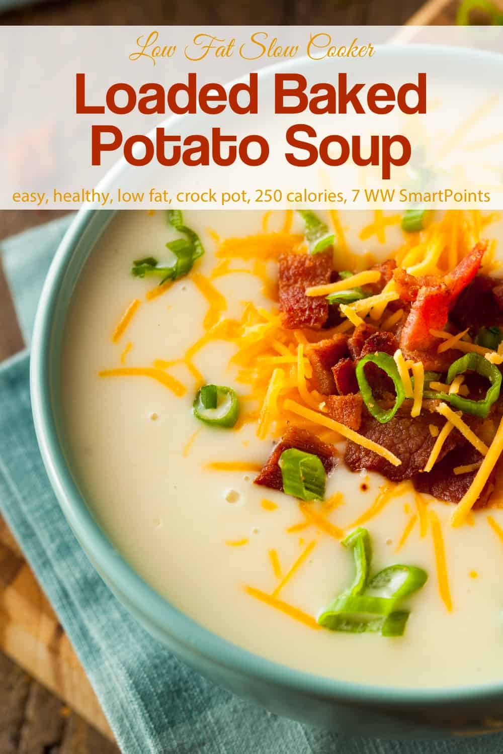 Loaded baked potato soup topped with crispy chopped bacon, sliced green onion and cheddar cheese in blue bowl.