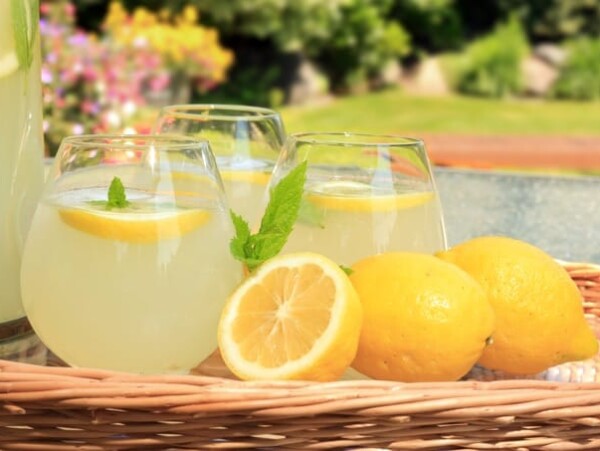 Basket with 3 glasses of fresh lemonade with lemons on the side