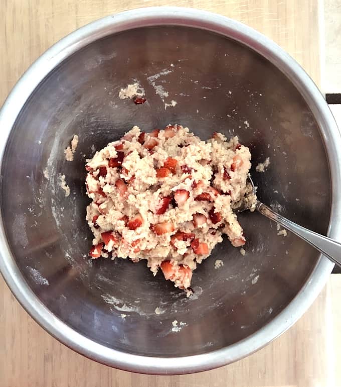 Strawberry shortcake cookie batter in mixing bowl with spoon