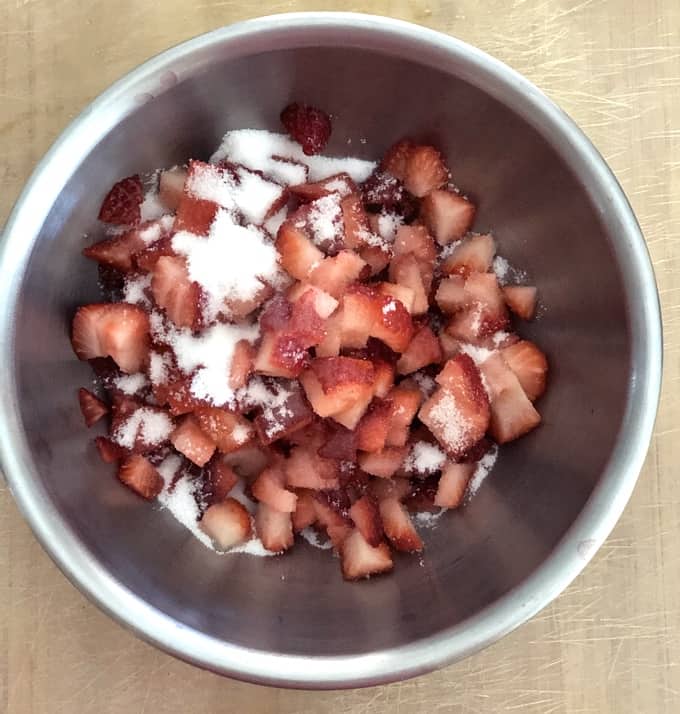 Mixing bowl with strawberries, sugar and lemon juice