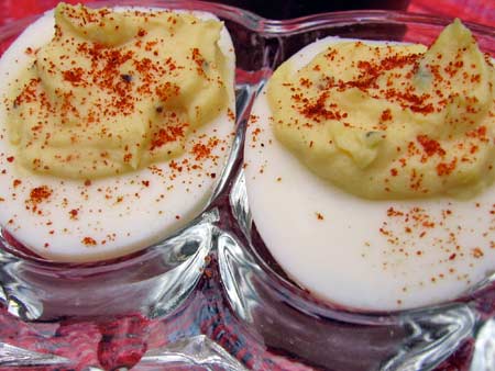 Deviled Egg sprinkled with paprika on small plate.