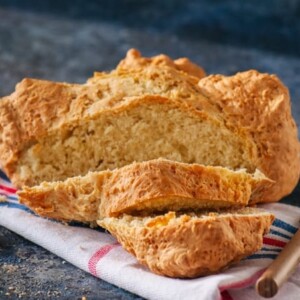 Traditional Irish soda bread on a towel on a blue stone background.