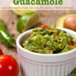 Homemade guacamole with tomatoes, onion, cilantro and jalapeño in small white dish
