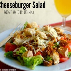 Cheeseburger Salad on white plate with iced tea alongside