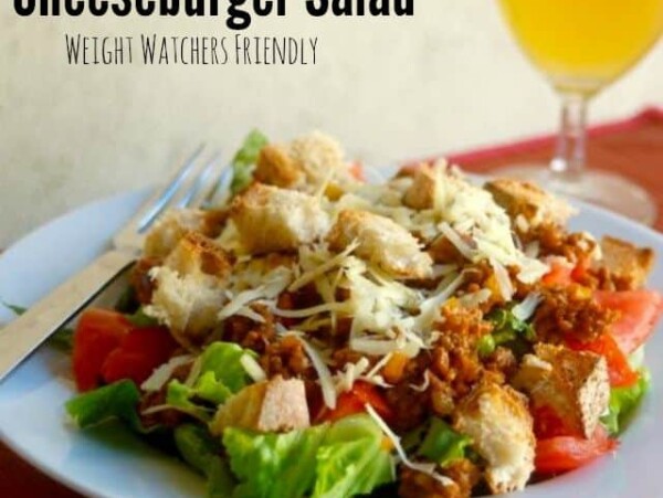 Cheeseburger Salad on white plate with iced tea alongside