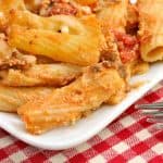 Close UP of Baked Ziti with Cottage Cheese on White Plate Red Checked Tablecloth