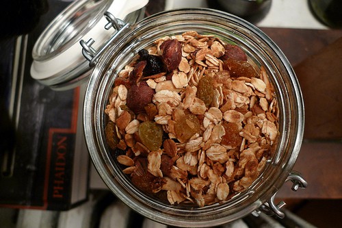 Homemade granola with raisins in glass jar with lid.