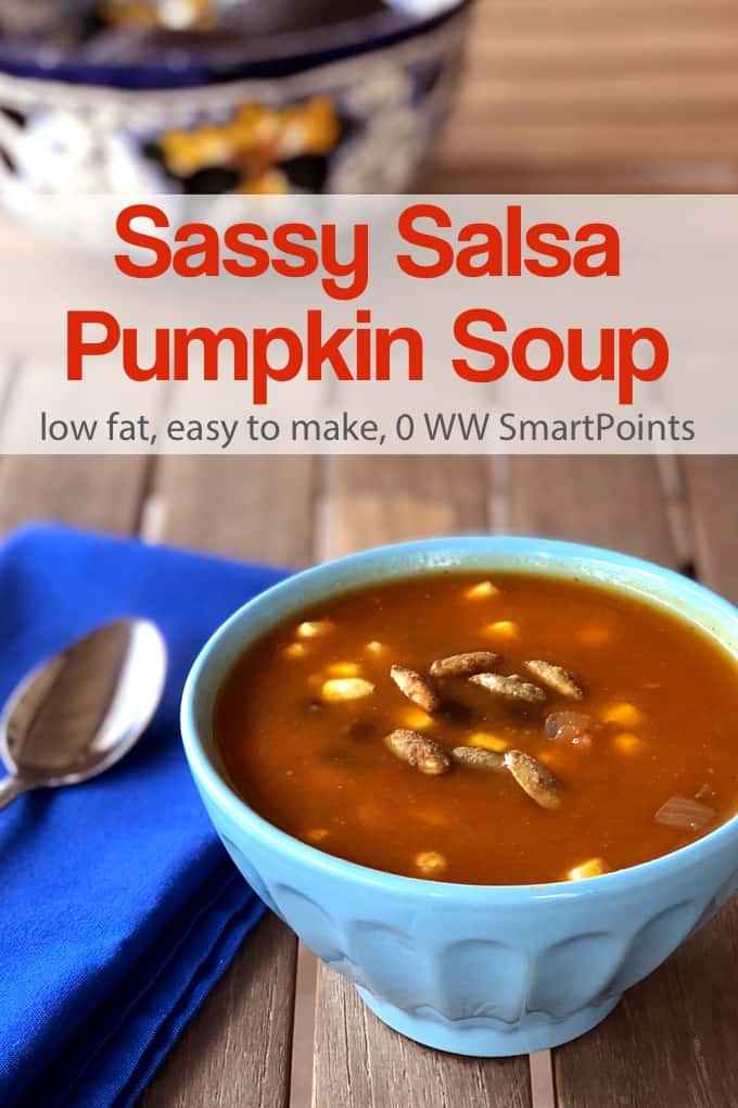 Salsa Pumpkin Soup in a blue bowl with blue napkin and spoon on a wood table