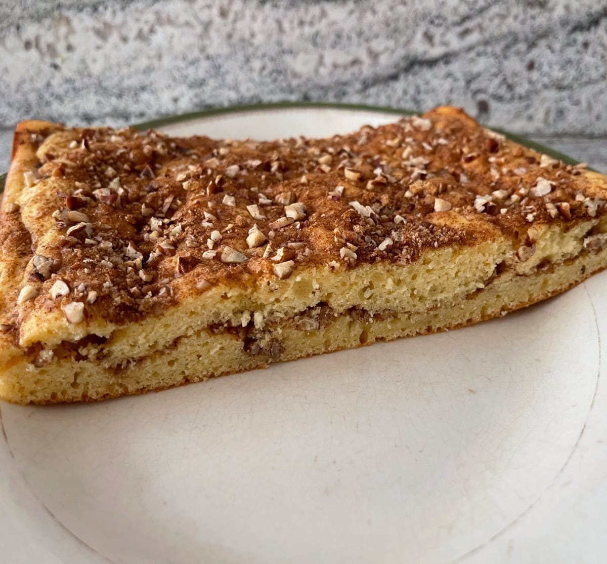 Cinnamon streusel coffeecake cut in half on serving platter.