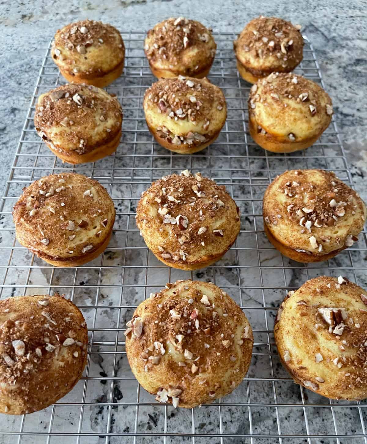 Fresh baked cinnamon streusel muffins cooling on a wire rack.