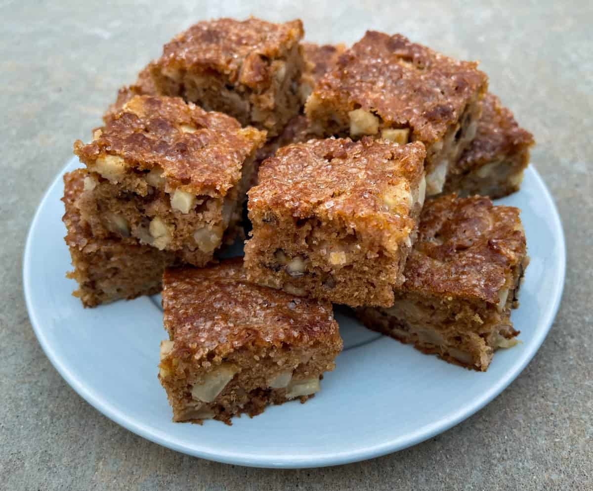 Fresh Apple Brownie Nut Bars stacked on round serving plate.