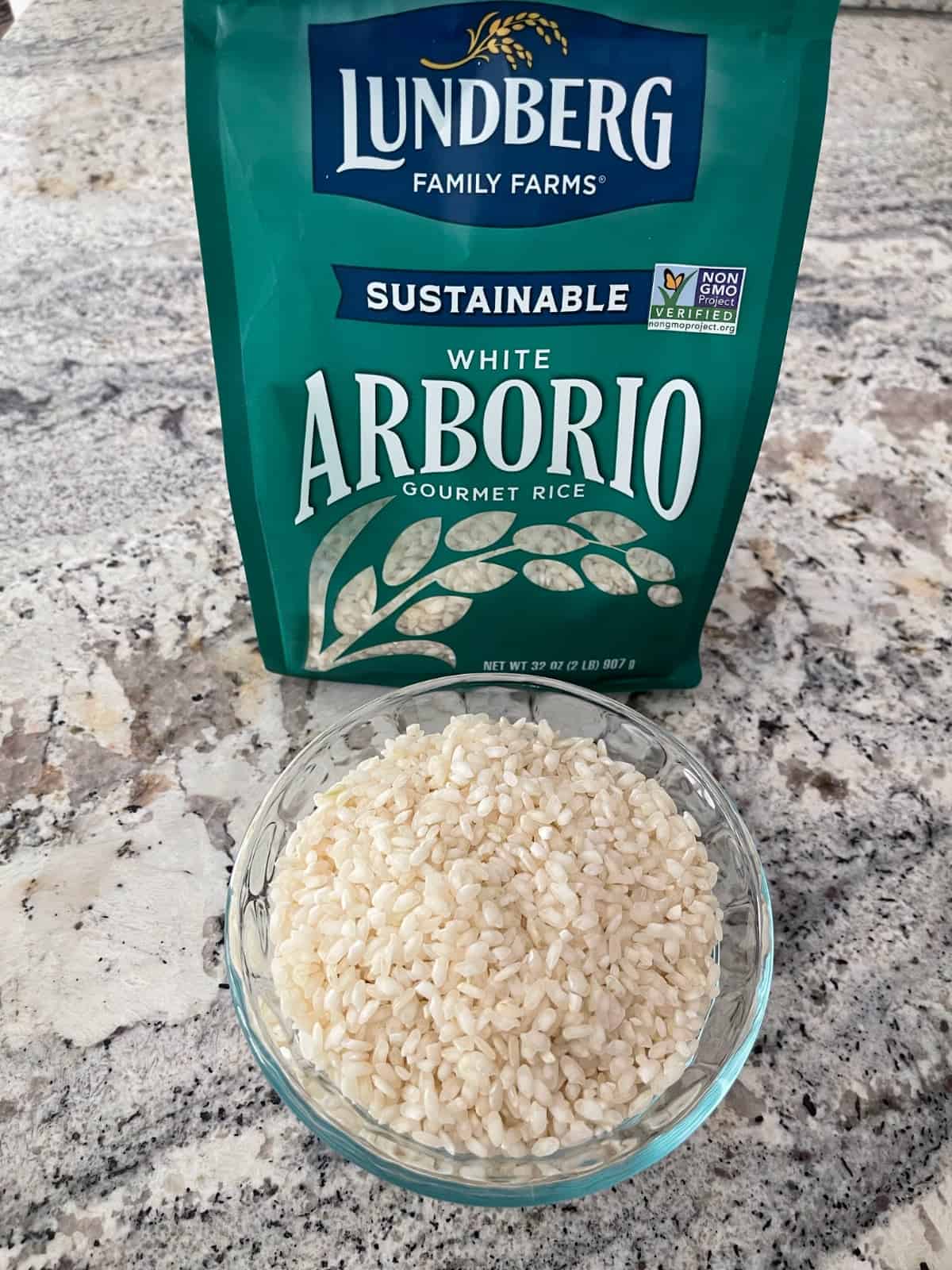 Package of Lundberg white Arborio rice with some rice in a small glass bowl.