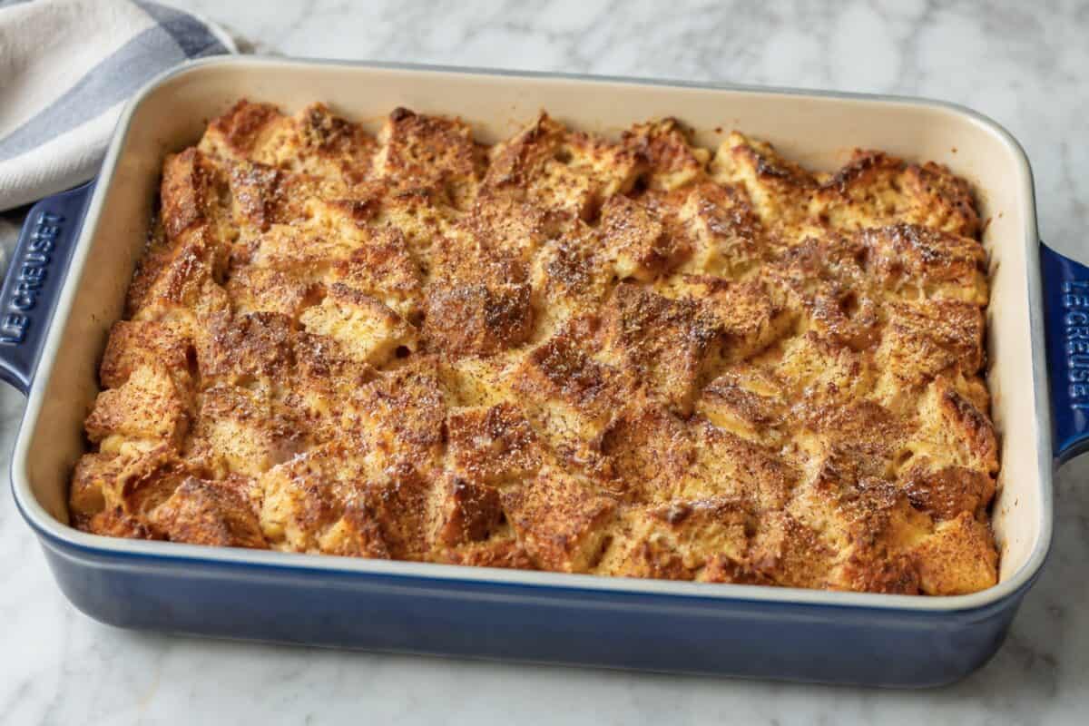 Fresh baked French toast in enameled blue casserole dish.