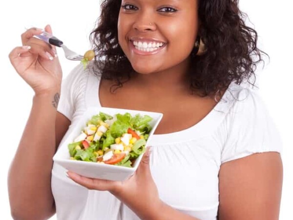 Young woman eating fresh green salad