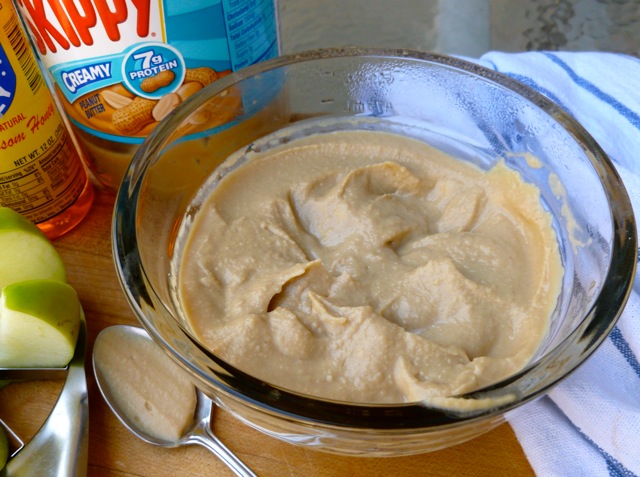 Creamy Peanut Butter Dip in small glass bowl with spoon.