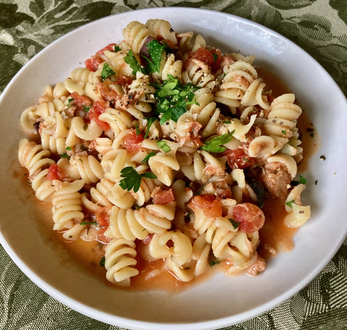 Mediterranean Pasta with Tuna and Tomatoes on white dinner plate.