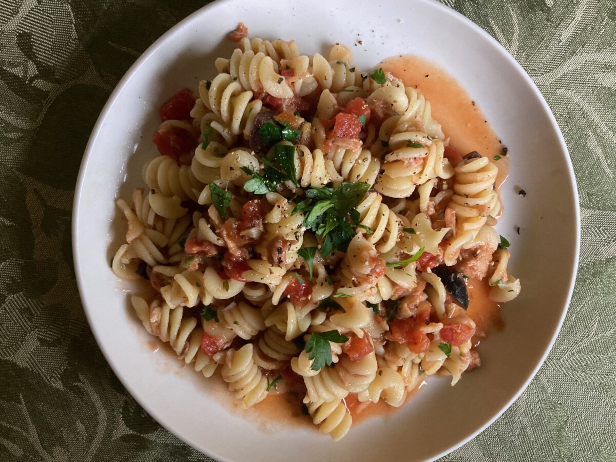 Mediterranean Pasta with Tuna and Tomatoes on white dinner plate.