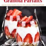 Two Strawberry Granola Parfaits with non-fat Greek yogurt and honey or maple syrup in glasses with spoons.