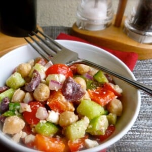 skinny chopped greek salad white bowl fork alongside beige mat