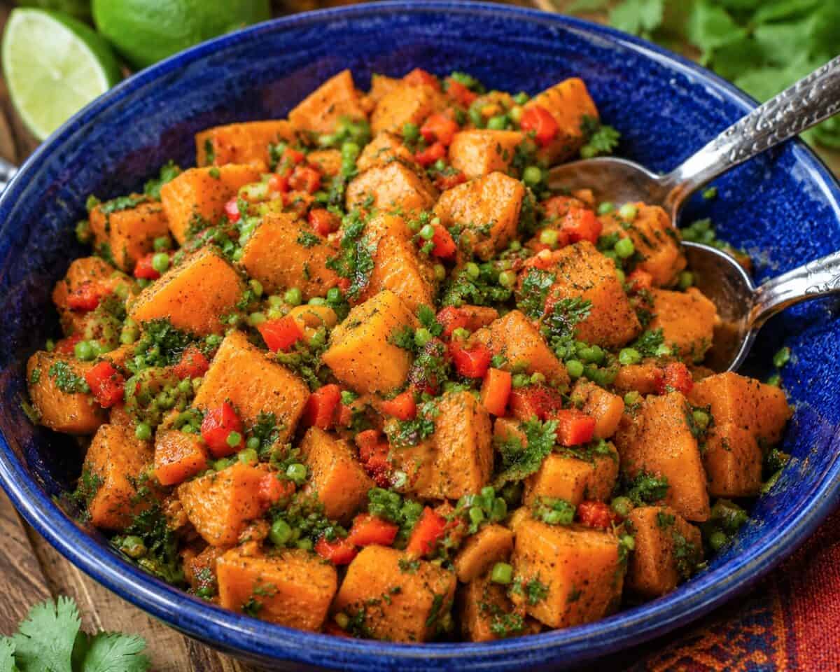 Southwest Sweet Potato Salad in blue bowl with serving spoons.