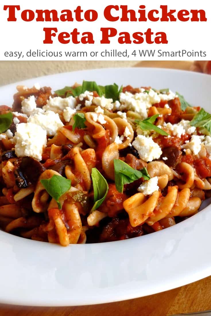 Tomato, Feta and Chicken Pasta topped with chopped basil in a white bowl