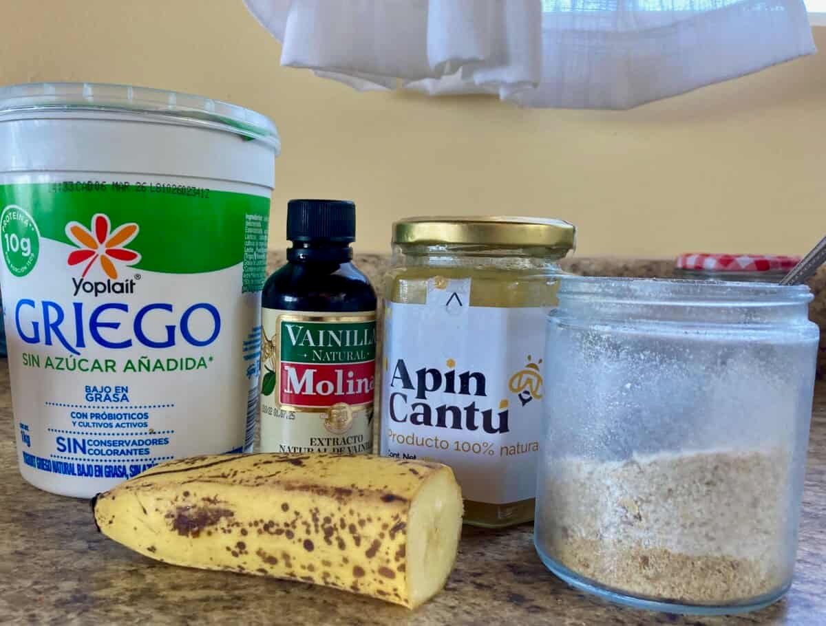 Plain Greek yogurt, vanilla, honey, wheat germ, banana on kitchen counter