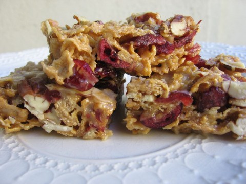Maple Cranberry Crunch Cereal Bars stacked on a plate.