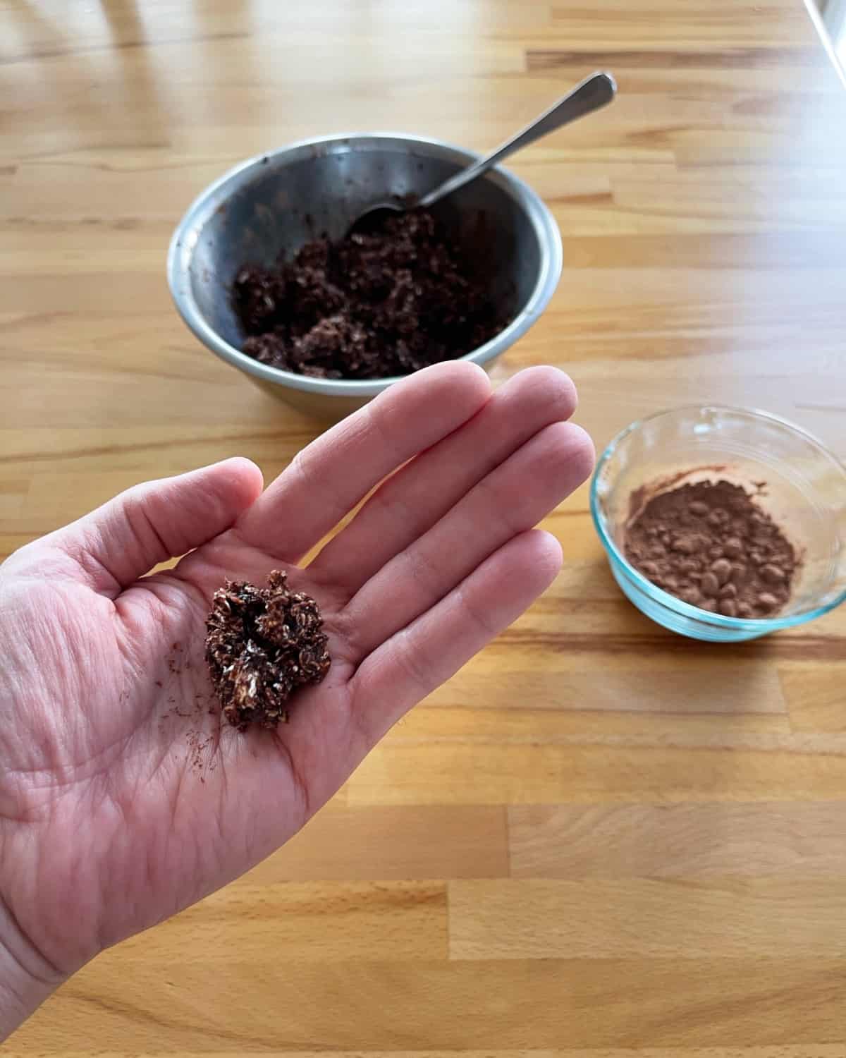 Rolling cranberry chocolate truffles in palm of hand.