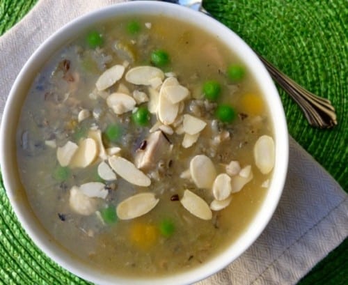 wild rice soup in a white bowl garnished with slivered almonds from above