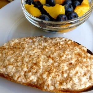 Cottage Cheese on Toast with Cinnamon alongside bowl of blueberries and peaches