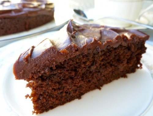 Slice of Chocolate Stout Cake with Chocolate Ganache Icing on a plate up close