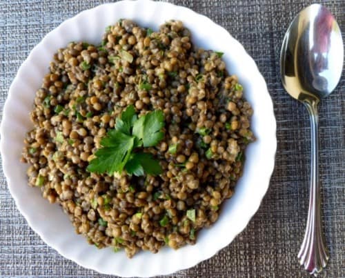 Simple Lentil Salad on white platter with serving spoon.