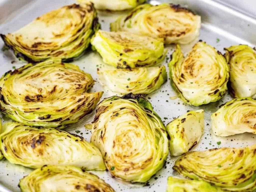Roasted cabbage wedges on sheet pan.