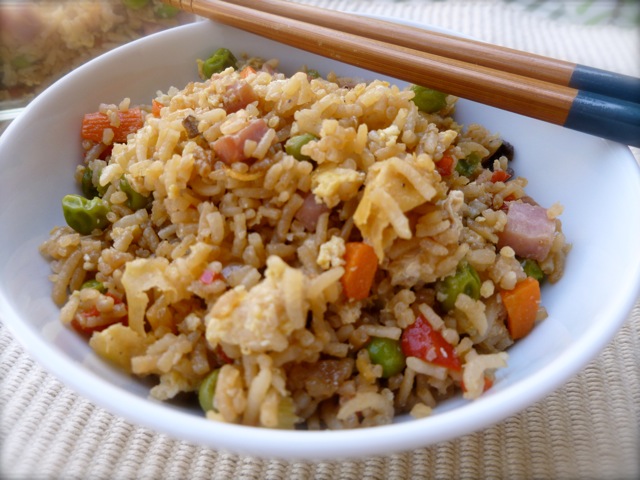 Fried Rice with Vegetables and Ham in white bowl with chopsticks.