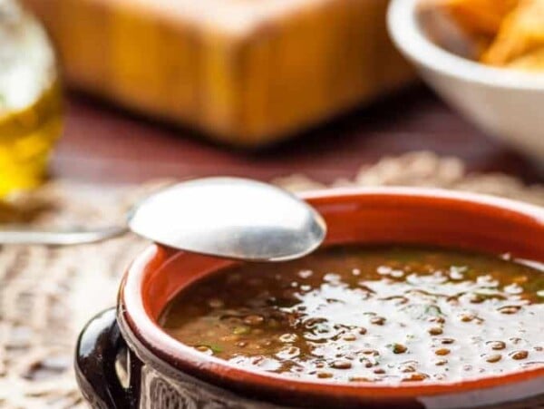 Bowl of vegetable beef lentil soup with a spoon