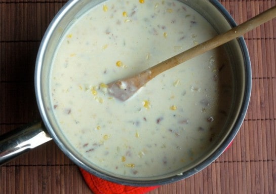Maine Corn Chowder in saucepan with wooden spoon.