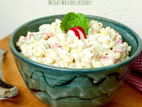 classic macaroni salad in green pottery bowl wood table