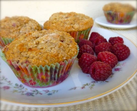 Raspberry Oatmeal Muffins on a white plate with fresh raspberries