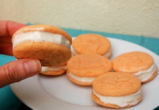 Orange Cake Mix Cookie Ice Cream Sandwiches with vanilla ice cream on serving platter.