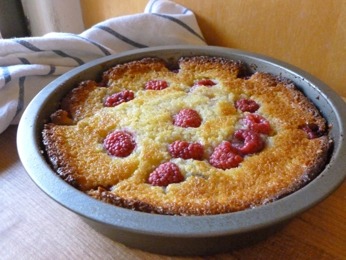 Fresh baked raspberry cake in baking tin.