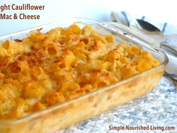 pyrex casserole dish filled with baked cauliflower macaroni and cheese on patterned tablecloth