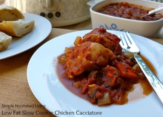 Slow Cooker Chicken Cacciatore on a dinner plate with the casserole dish in the background