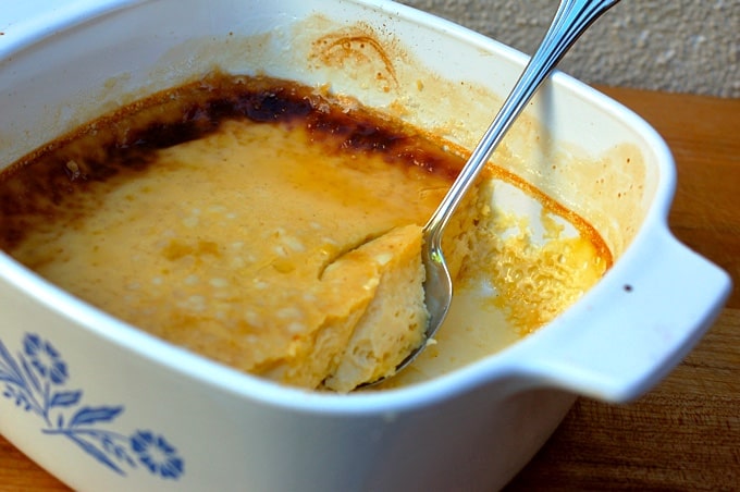 Crockpot creme brûlée in casserole dish with serving spoon.