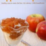 Apple compote over vanilla ice cream in dessert glass with fresh apples and cinnamon sticks off to the side.