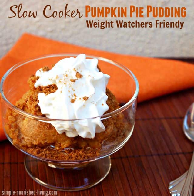 Slow Cooker Pumpkin Pie Pudding with whipped topping in dessert glass with spoon and orange napkin.