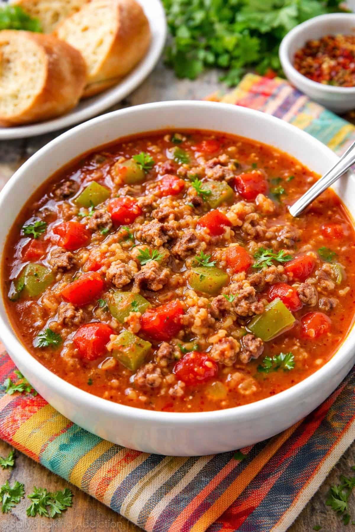 Slow Cooker Stuffed Pepper Soup in a white bowl with a spoon.